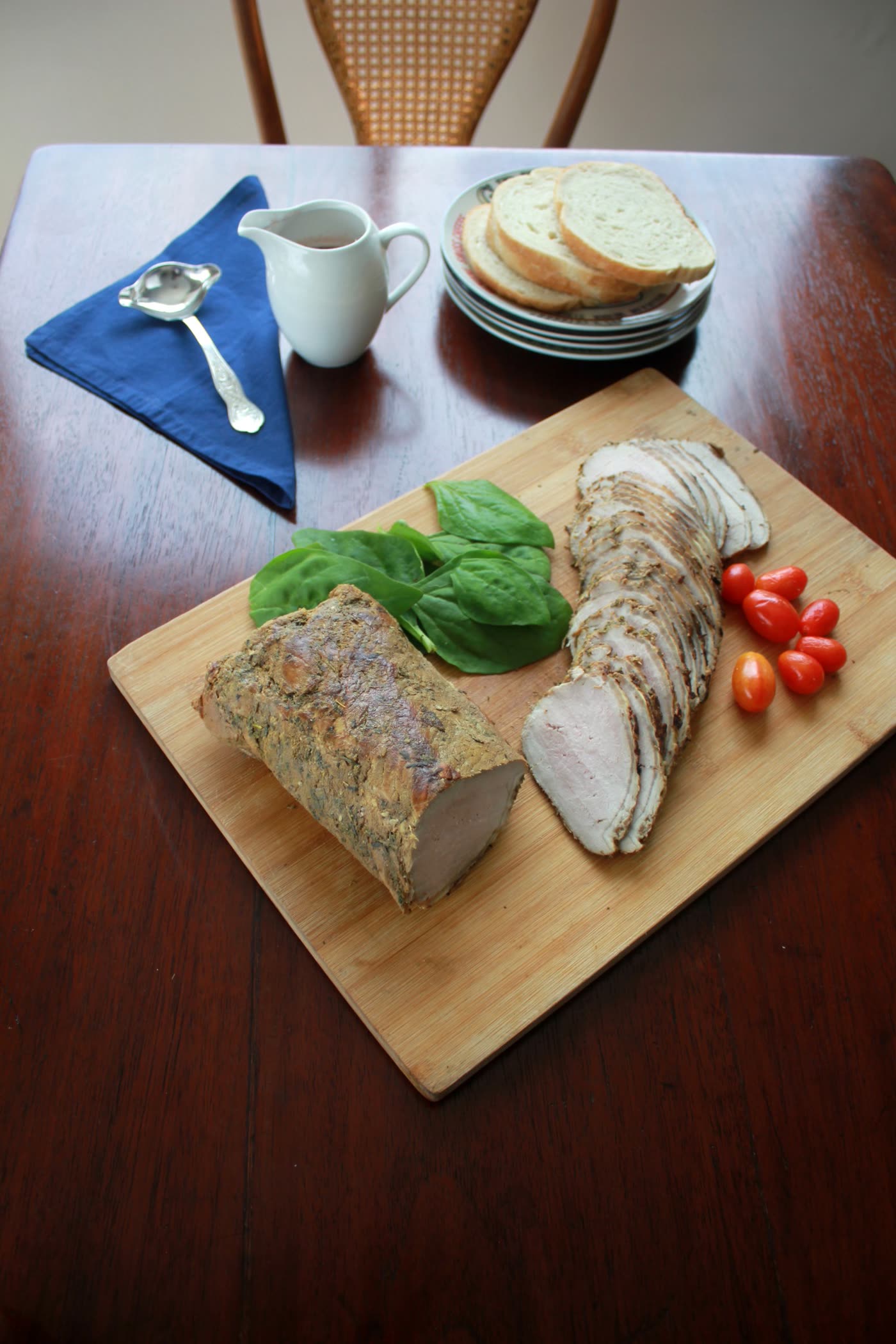 Lomo de cerdo entero y en rodajas sobre una tabla
